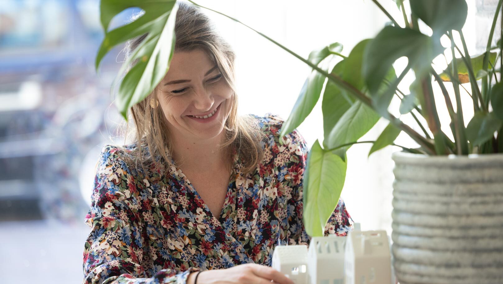 Medewerker van Nieuwenhuis Makelaardij in gesprek aan tafel met woningmaquette tijdens persoonlijk woonadvies